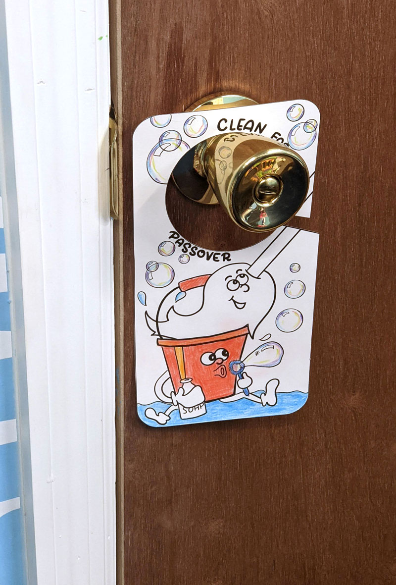 mom colored no chametz sign hanging from a doorknob