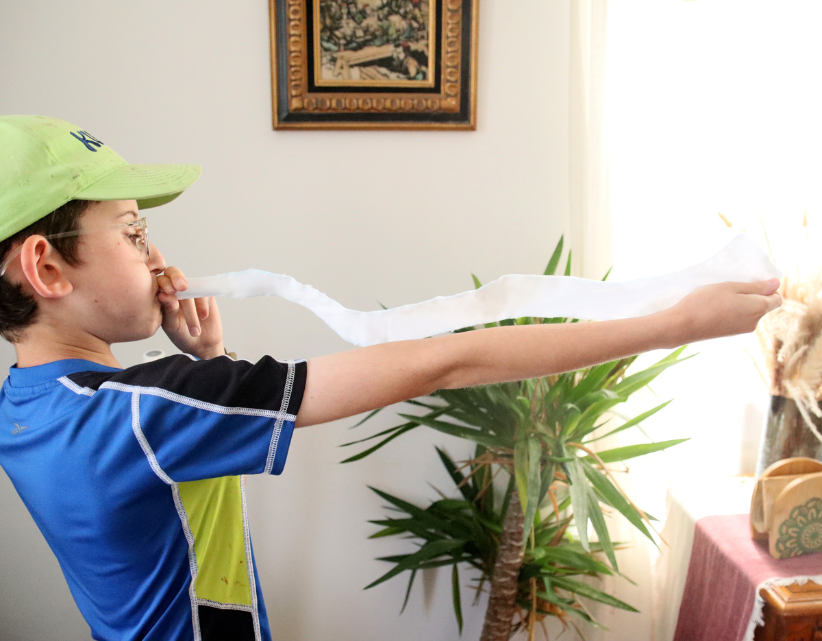 child blowing the large felt shofar 