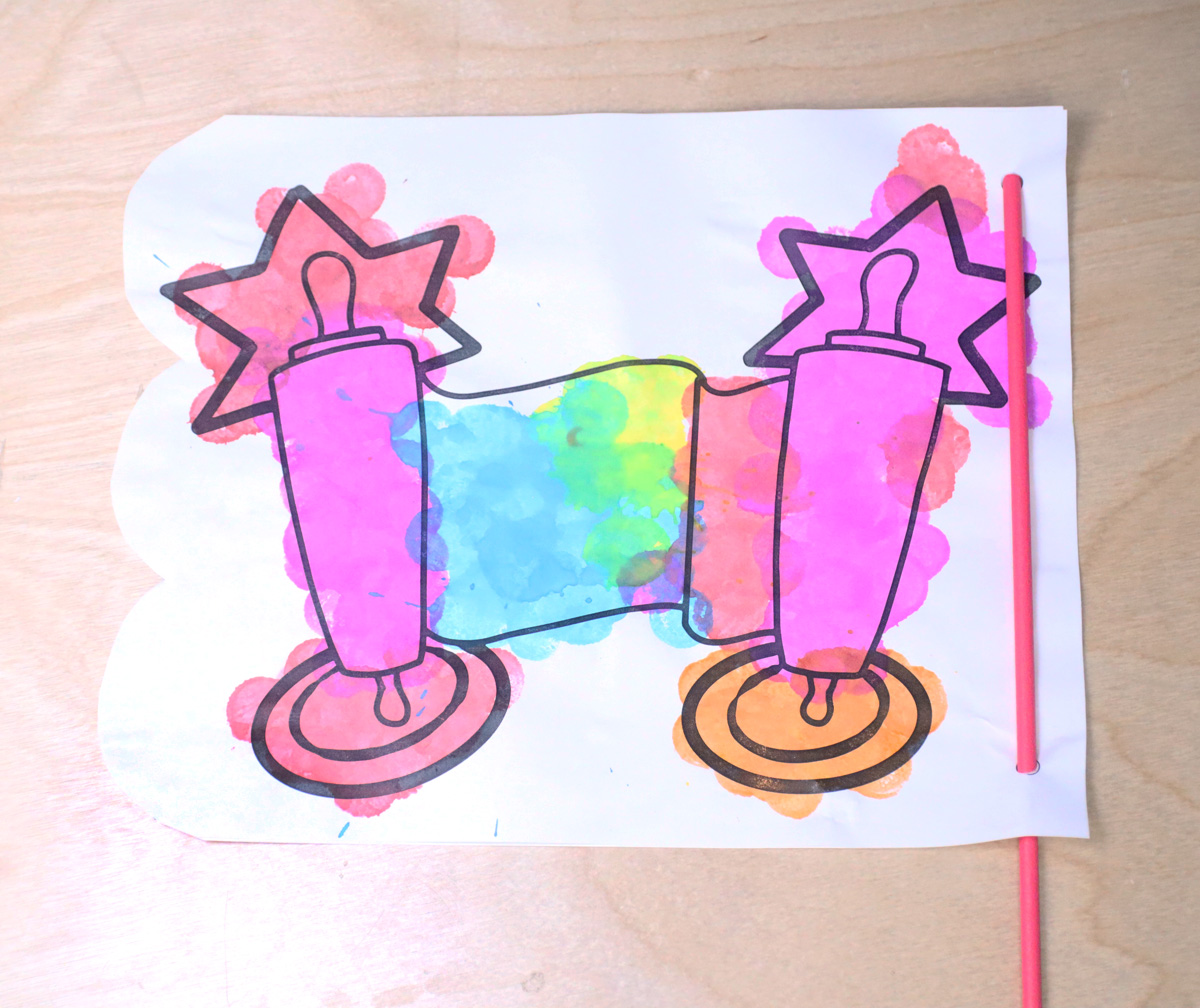 adding a dowel through the hole punches on the printable simchat torah flags craft